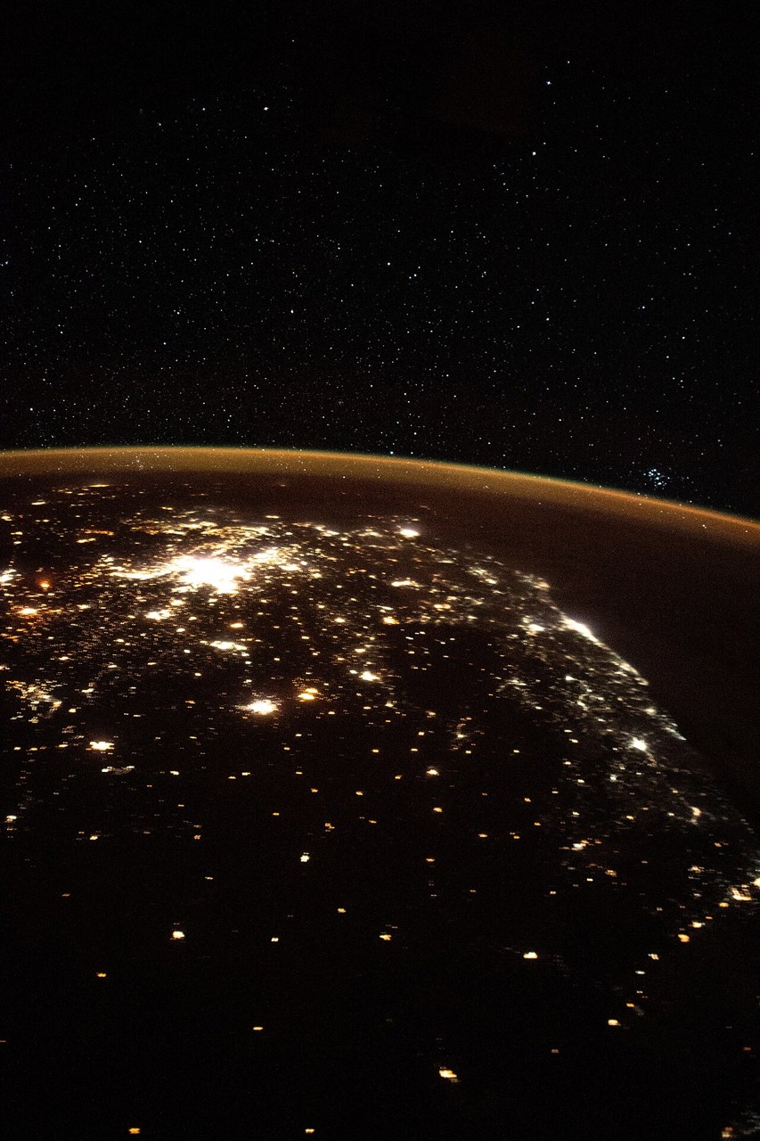 South African city lights beneath a curved glowing atmospheric horizon and stars, viewed from the ISS.