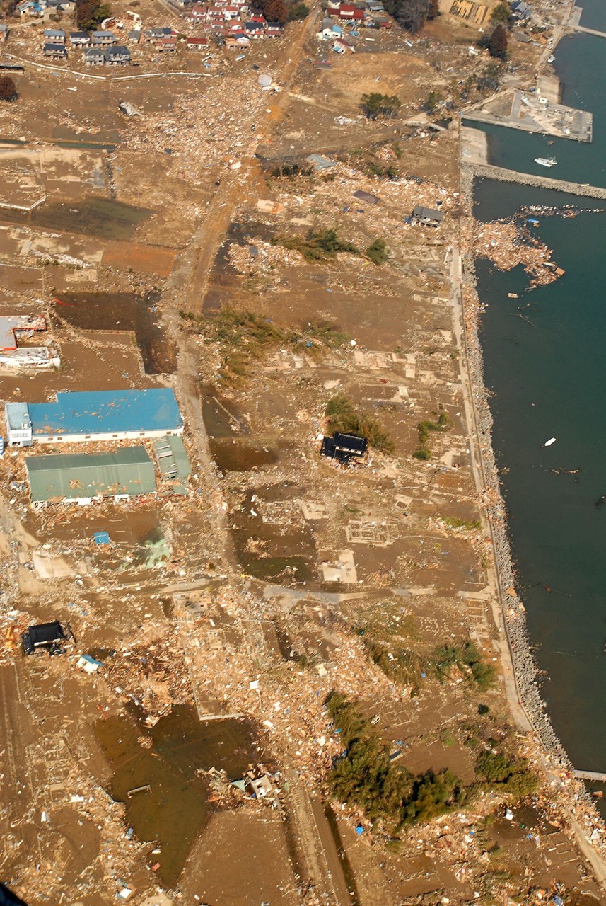 Debris, damaged buildings and inundated land at a fishing port near Kesennuma after the 2011 tsunami.